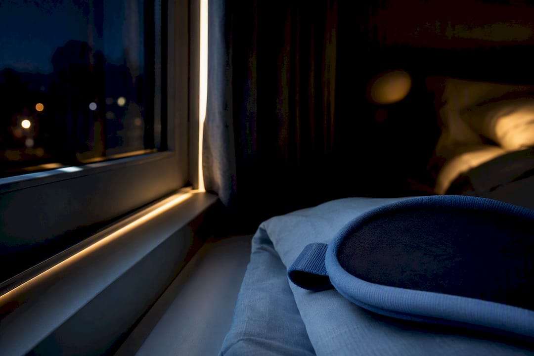 Slaapmasker houdt licht buiten in een donkere slaapkamer